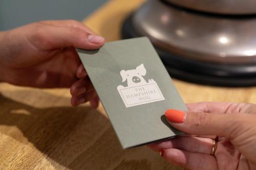 a person holding a card with a dog on it at The Hampshire Hog in Clanfield
