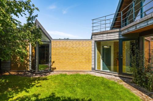an extension to a house with glass doors and a yard at Quiet villa apartment close to everything in Odense