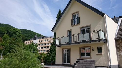 a white house with a balcony and buildings at Haus Hohenzollern & Haus 'Ambiente in Bad Bertrich