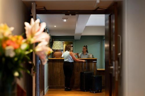 a woman standing at a bar in a room at The Hampshire Hog in Clanfield