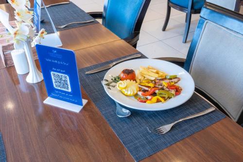 a plate of food on a table with a plate of food at Sumou Hotel Al Khobar in Al Khobar