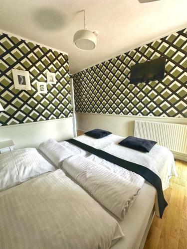 a bedroom with two beds and a wall with pictures at Willa Wydra in Krościenko