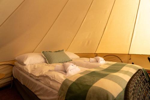 a bed in a tent with towels on it at Skårungen - Hotel, Cabins and Camping in Kabelvåg