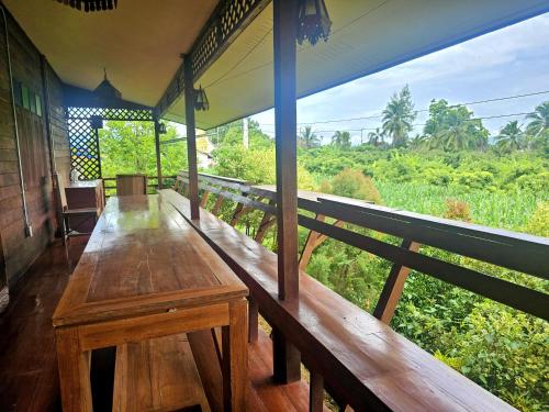 a porch of a house with a wooden table at ฮักจังโฮมสเตย์&คาเฟ่ in Chiang Mai