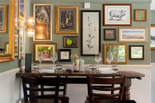 a dining room with a table and framed pictures on the wall at The Hampshire Hog in Clanfield