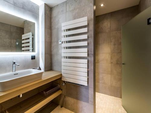 une salle de bain avec un lavabo et un miroir dans l'établissement Chalet de luxe 5* avec Spa, PMR, au pied des pistes - FR-1-398-621, à Montvalezan
