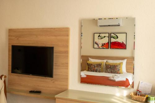 a bedroom with a bed and a flat screen tv at Uva Rooms in Fethiye