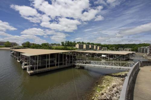 a dock with a building on a body of water at Reflections 2bd2babalconypoolshottub-4pp in Lake Ozark