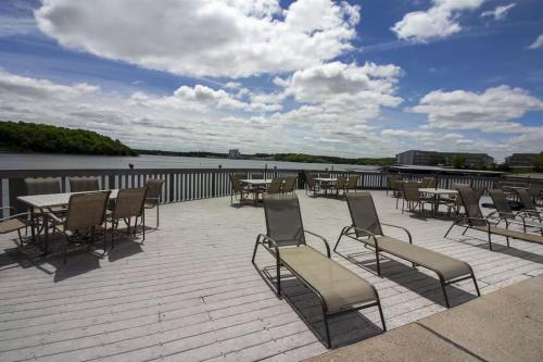 a group of chairs and tables on a patio next to the water at Reflections 2bd2babalconypoolshottub-4pp in Lake Ozark