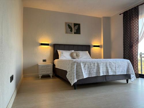 a bedroom with a bed and two lamps and a window at Villa with Pool & View in Bitez in Bodrum City