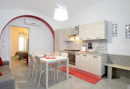テルモリにあるLa Casetta di Maryのキッチン、ダイニングルーム(白いテーブル、椅子付)