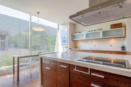 a kitchen with wooden cabinets and a large window at Stars View by Portugal Active in Fafe