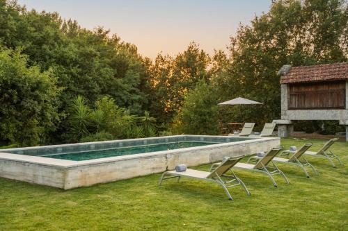 a swimming pool with lounge chairs and a table at Stars View by Portugal Active in Fafe