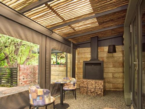 a patio with a tv and a table and chairs at Calm Clarens in Clarens