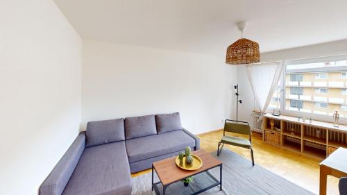 un soggiorno con un divano blu e un tavolo di Basic & Simple on Langgrütstrasse a Zurigo