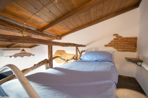 a bed in a room with a wooden ceiling at B&B Sinis Domus in Siniscola