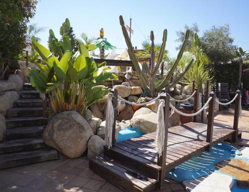 a garden with a wooden bridge and some plants at Hotel Alba Seleqtta in Lloret de Mar