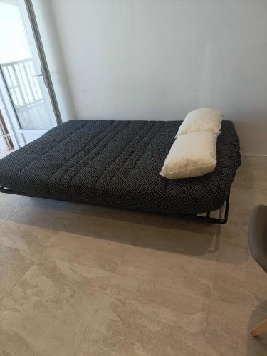 een bed met twee kussens erop in een kamer bij LES CORAUX AGAY in Agay - Saint Raphael