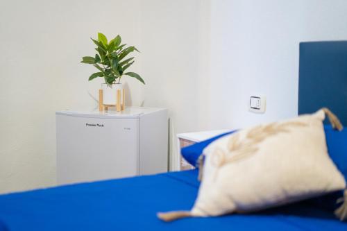 a blue bed with a pillow and a potted plant at B&B Sinis Domus in Siniscola