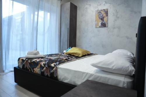 una camera da letto con un letto con cuscini e una finestra di Spend Night a Napoli