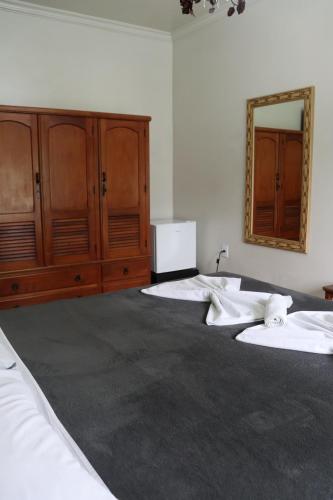 two beds in a room with a mirror on the wall at Hotel Casa Encantada in Penedo