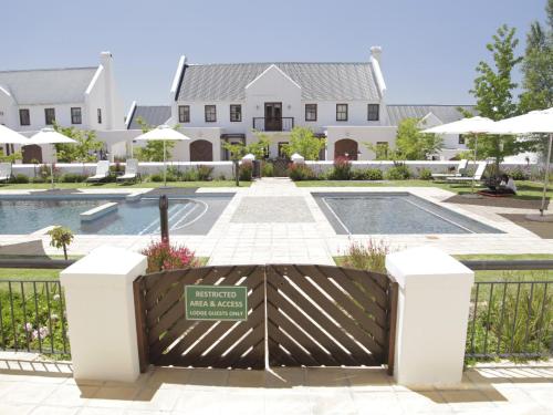 a gate in front of a house with a pool at Winelands Golf Lodges 3 in Stellenbosch