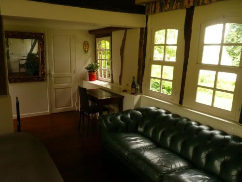 a living room with a leather couch and a table at La Bonne Auberge - Seine Panorama SAS in Vieux-Port