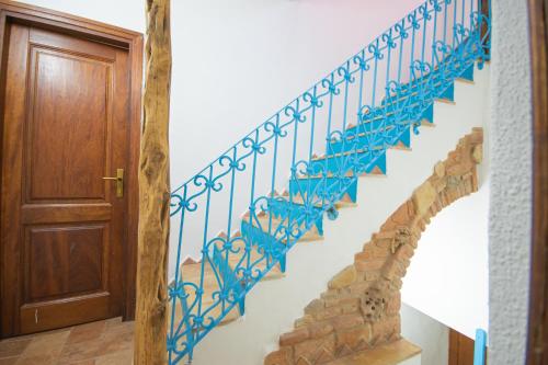 a staircase in a house with a blue railing at B&B Sinis Domus in Siniscola