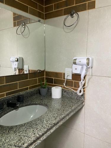 a bathroom counter with a sink and a mirror at Hotel Casa Encantada in Penedo