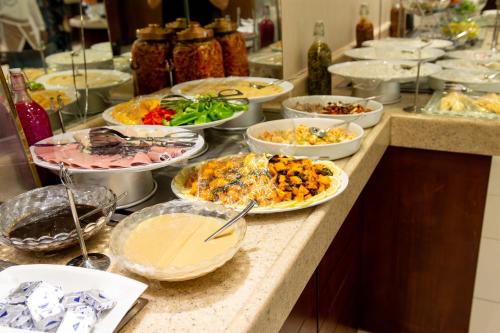 a buffet with many plates of food on a counter at Sumou Hotel Al Khobar in Al Khobar