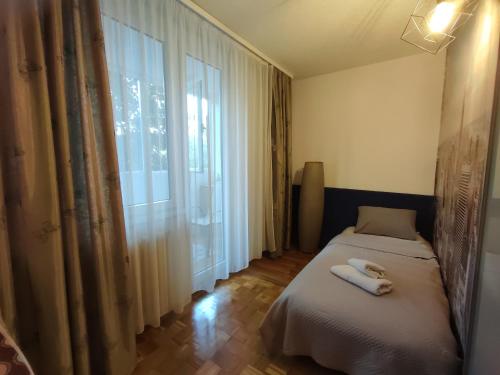 萨拉热窝Azer的一间卧室，配有两张床和一个大窗户