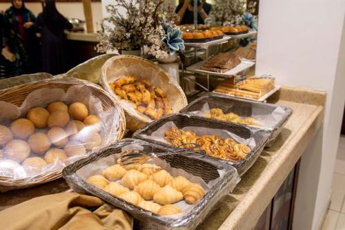a buffet with many different types of bread and pastries at Sumou Hotel Al Khobar in Al Khobar