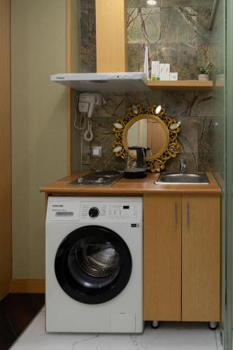 a washing machine in a kitchen with a sink at Arnas hotel in Almaty