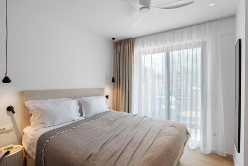 Un dormitorio con una cama y una ventana grande. en Neapolis, en La Canea
