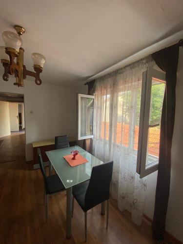 a dining room with a table and chairs and a window at Lana in Cetinje