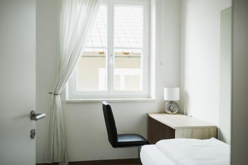 a bedroom with a desk and a chair and a window at R&R Residenzen Ferienwohnungen in Mitterbach