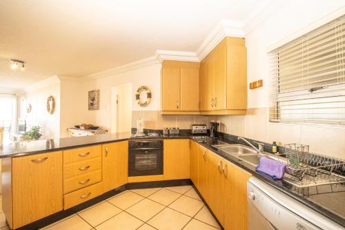 a large kitchen with wooden cabinets and a sink at Praslin 4 in Margate