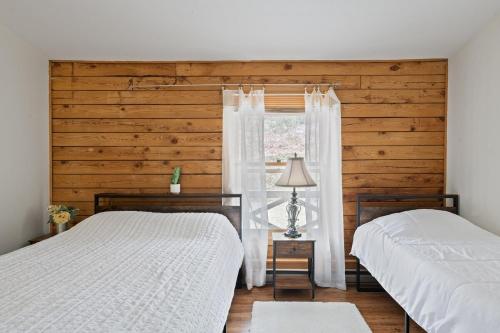 a bedroom with two beds and a window withermottermottermott at 5 min to Lake Chic Cozy Hot Tub in Sparta