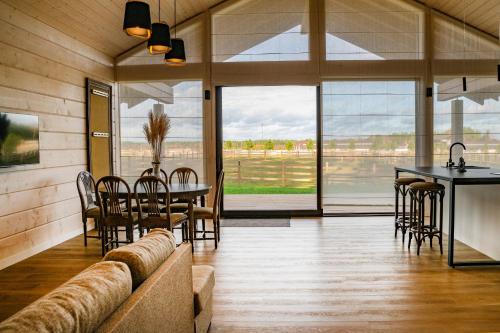 a dining room with a table and chairs and glass doors at Royal Horse Resort in Balkasodis