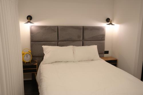 a bedroom with a large white bed with two lights at Puy Castele Hotel Tiberias in Tiberias