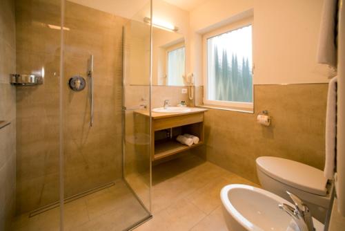 a bathroom with a shower and a sink and a toilet at Pension Grohmann in Santa Cristina in Val Gardena