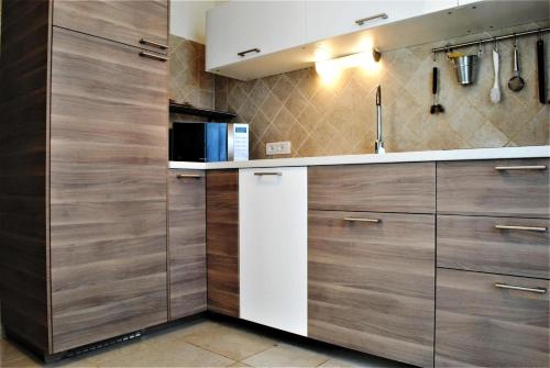 a kitchen with wooden cabinets and a white refrigerator at Villa Florida 1 with private pool in San Teodoro