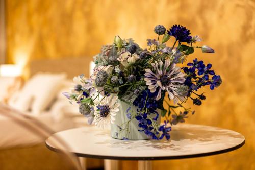 a vase filled with blue and white flowers on a table at Albergo La Rocca in Brisighella