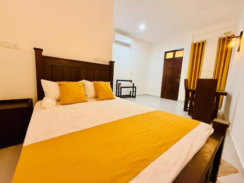 a bedroom with a large bed with yellow pillows at Seven Shape Resort - Talalla in Talalla