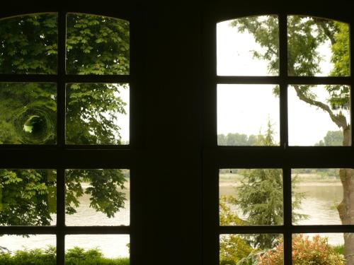 an open window with a view of a river seen through it at La Bonne Auberge - Seine Panorama SAS in Vieux-Port