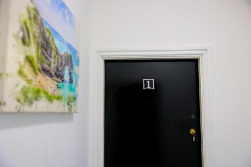 a black door with a picture on the wall at Edinburgh Road Guest House in Liverpool