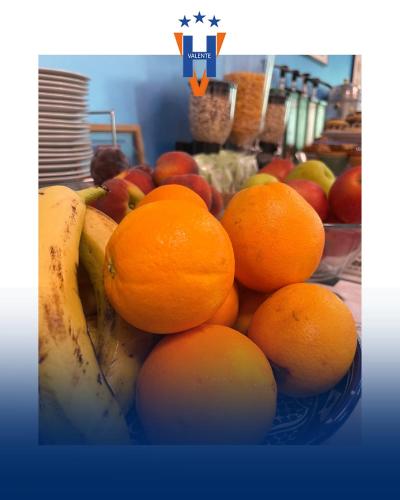a bowl of fruit with oranges and apples on a table at Hotel Valente in Ortona