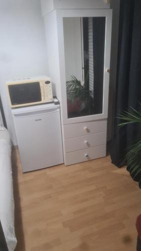 Cette chambre comprend un four micro-ondes installé au-dessus d'un réfrigérateur. dans l'établissement QuickHosting Bordeaux Centre, à Bordeaux