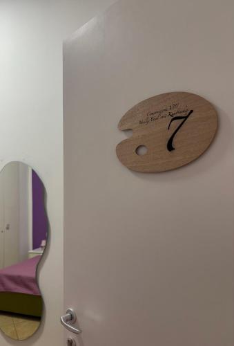 a wooden clock on a wall next to a guitar at Il dipinto in Reggio Calabria