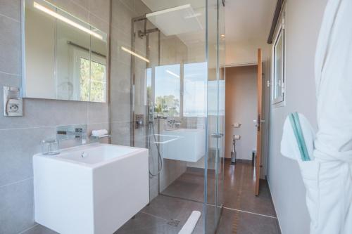 a bathroom with a sink and a glass shower at Kube Saint-Tropez in Saint-Tropez
